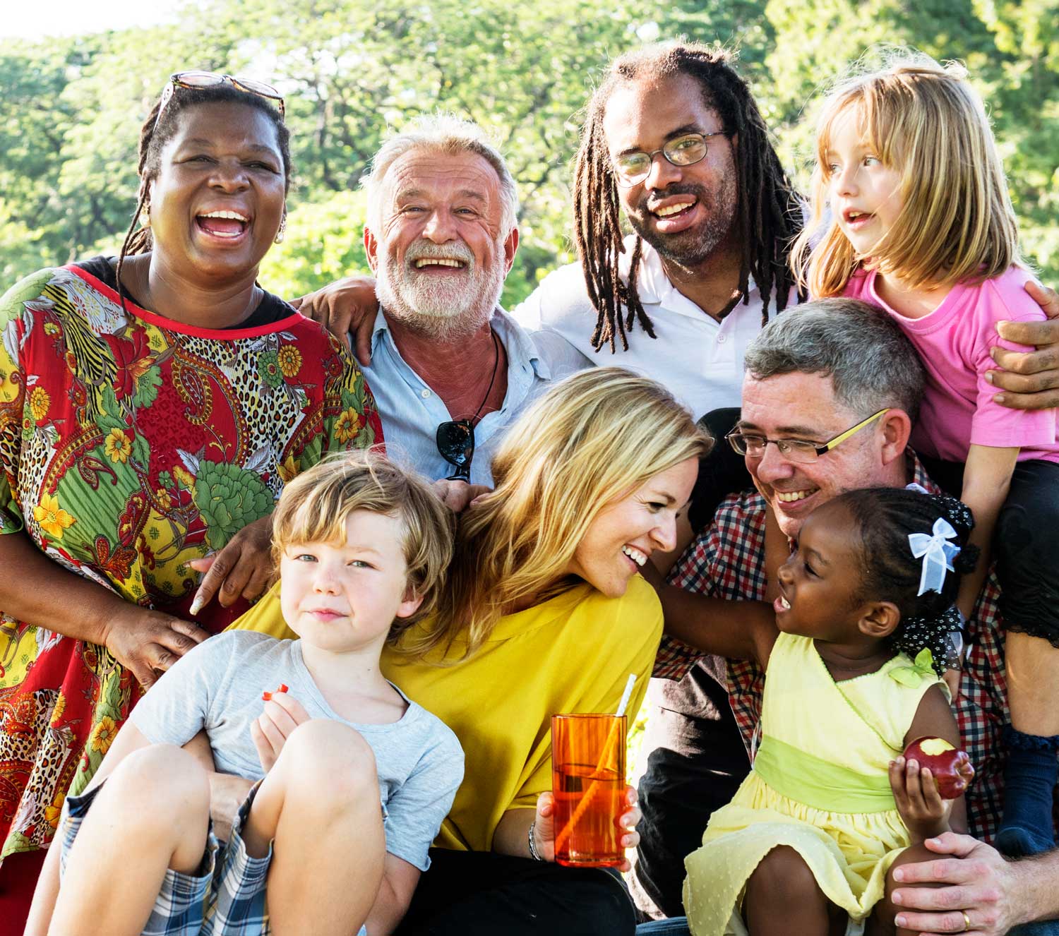 Multigenerational family enjoying a picnic and laughing together outdoors.